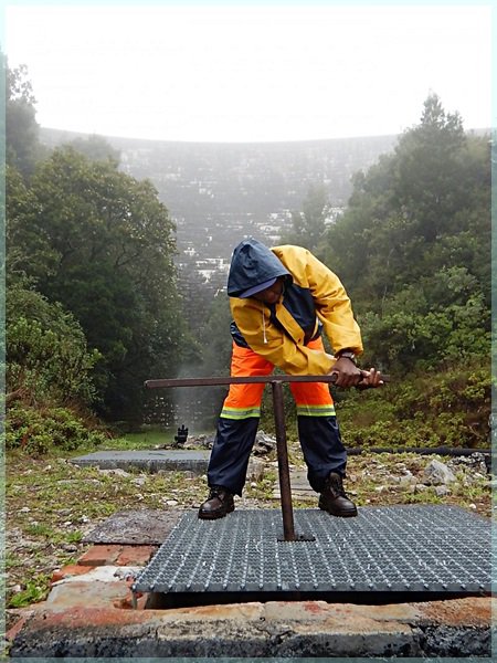 man adjusting outflow at the base of Woodhead Dam